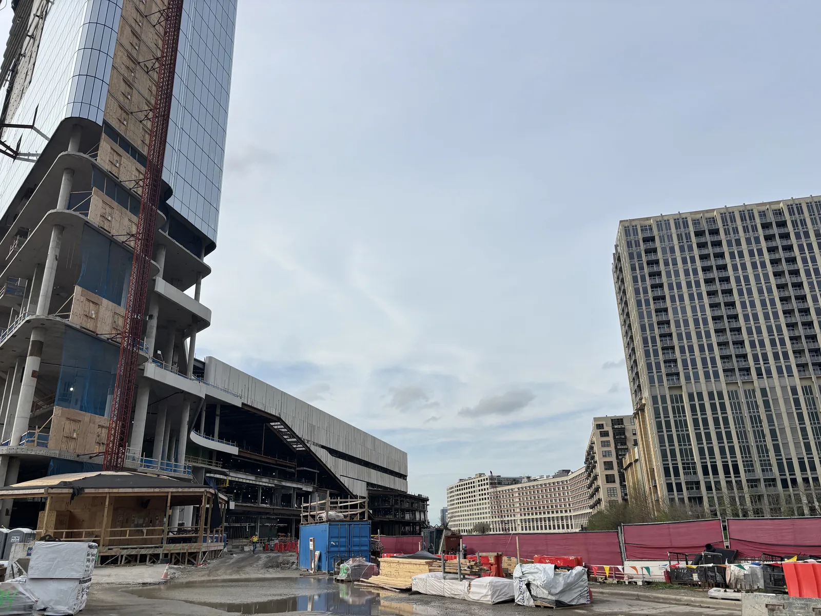 A curtain wall panel on a tower crane line above a Chicago high-rise under construction